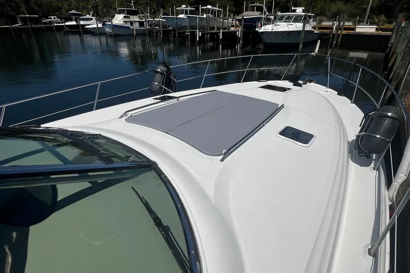 Slide: The Image of 2003 Sea Ray 410 Express Cruiser docked, showcasing sleek deck design and marina backdrop. - 21