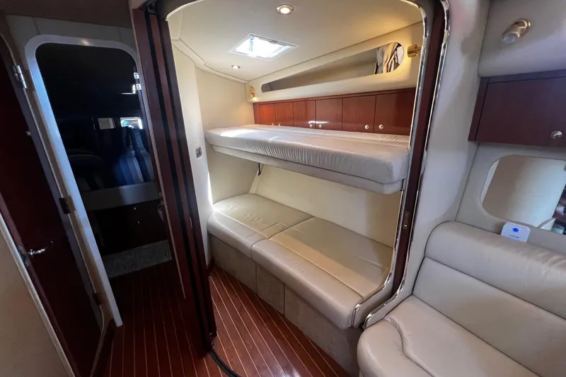 Slide: The Image of 2003 Sea Ray 410 Express Cruiser interior with bunk beds and wooden flooring. - 22