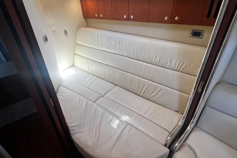 Slide: The Image of Interior of 2003 Sea Ray 410 Express Cruiser with white leather seating and wooden cabinets. - 25