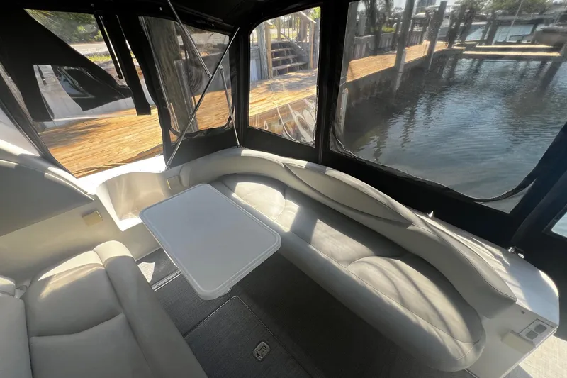Slide: The Image of Interior view of 2003 Sea Ray 410 Express Cruiser with seating and table by the water. - 33