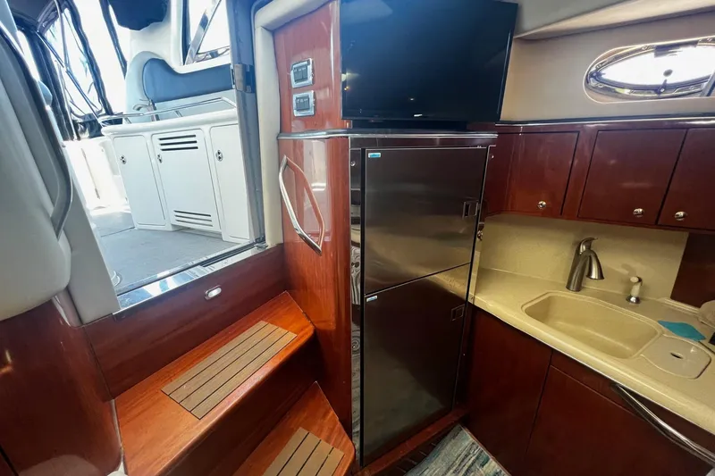 Slide: The Image of Interior of 2003 Sea Ray 410 Express Cruiser with kitchenette and stairs to deck. - 36