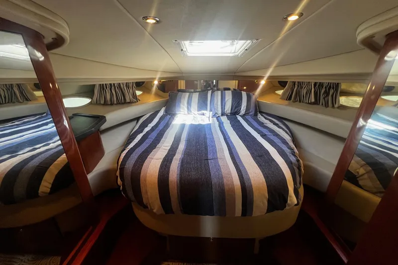 Slide: The Image of Luxurious cabin interior of 2003 Sea Ray 410 Express Cruiser with striped bedding. - 38