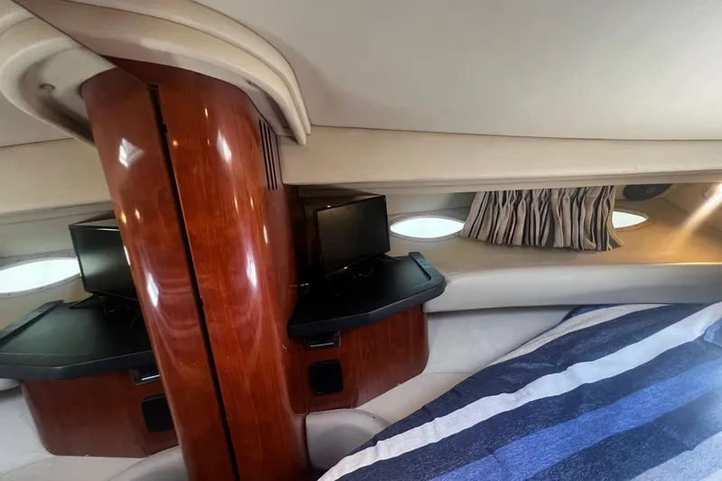 Slide: The Image of Interior of 2003 Sea Ray 410 Express Cruiser with wood paneling and striped bedding. - 45