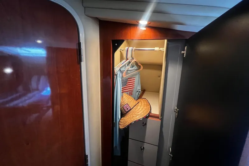 Slide: The Image of Interior closet of 2003 Sea Ray 410 Express Cruiser with hangers and hat. - 46