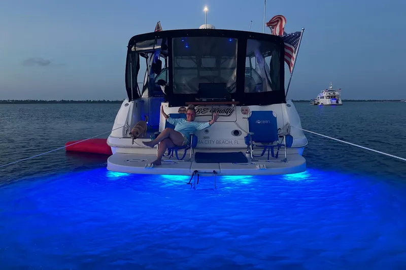 Slide: The Image of 2003 Sea Ray 410 Express Cruiser with blue underwater lights at dusk. - 50