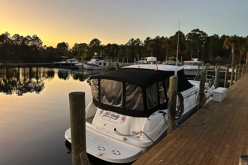 Slide: The Image of 2003 Sea Ray 410 Express Cruiser docked at sunset in a serene marina. - 54