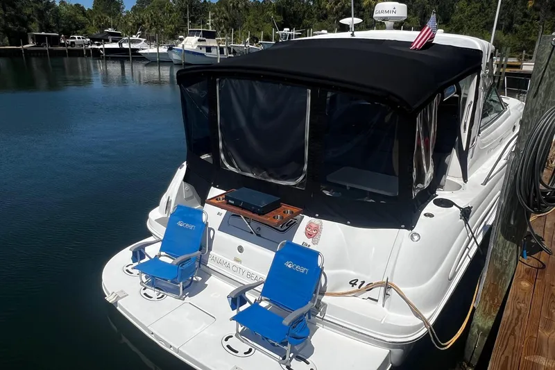 Slide: The Image of 2003 Sea Ray 410 Express Cruiser docked with chairs on the swim platform. - 6