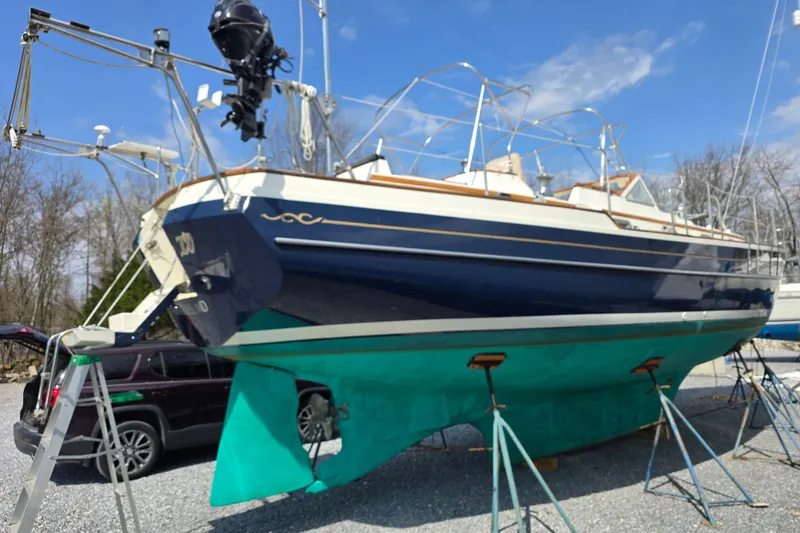 Slide: The Image of 1998 Gozzard 44 Center Cockpit sailboat on stands, blue hull, outdoor setting. - 1