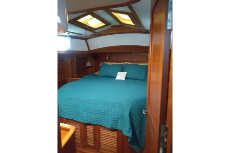 Slide: The Image of Luxurious cabin interior of 1998 Gozzard 44 Center Cockpit with teal bedding and wooden accents. - 4