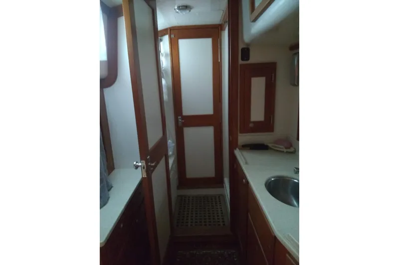 Slide: The Image of Interior of 1998 Gozzard 44 Center Cockpit yacht, featuring wooden cabinetry and compact sink. - 6