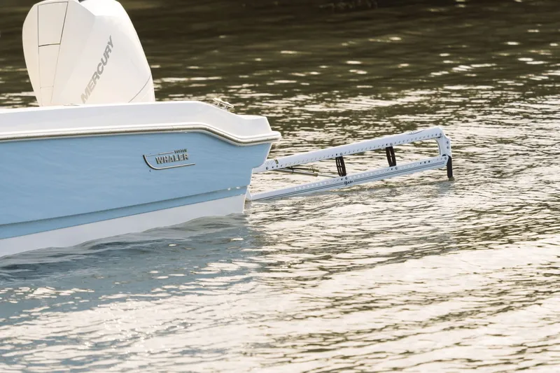 Slide: The Image of The image shows the stern of a 2027 Boston Whaler 220 Dauntless in the water. - 47