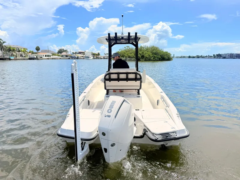 Slide: The Image of 2027 Boston Whaler 220 Dauntless on calm water with outboard motor and T-top. - 11