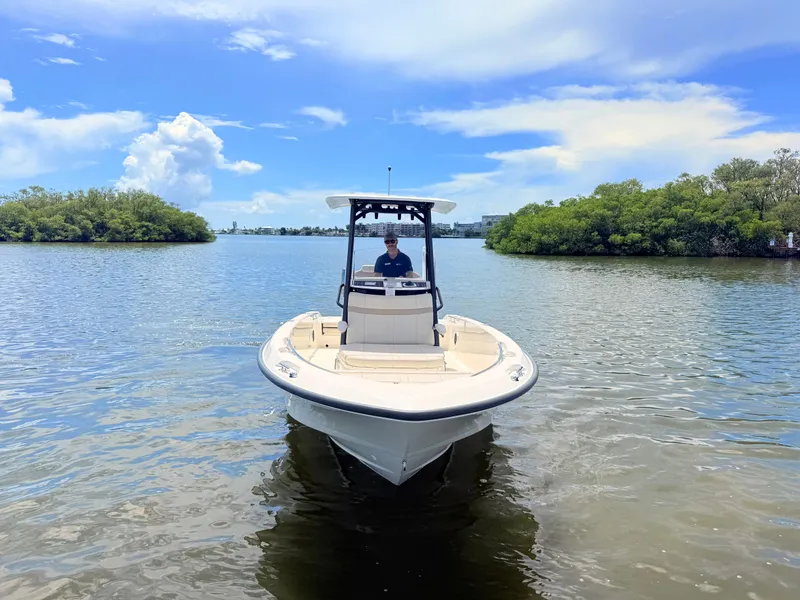 Slide: The Image of A 2027 Boston Whaler 220 Dauntless on calm water, surrounded by green vegetation. - 4