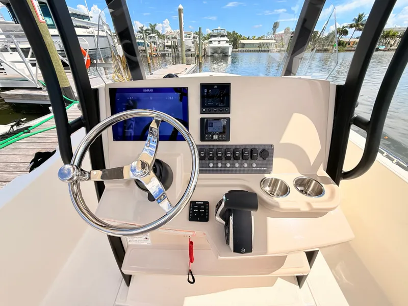 Slide: The Image of The image shows the helm of a 2027 Boston Whaler 220 Dauntless with modern instruments. - 30
