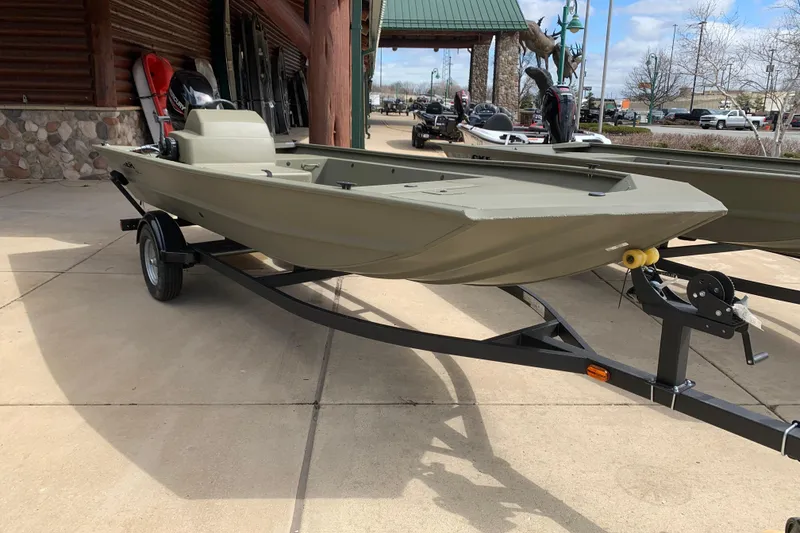 The Image of 2026 Tracker Grizzly 1754 SC All-Welded boat on trailer, parked outdoors. - 1