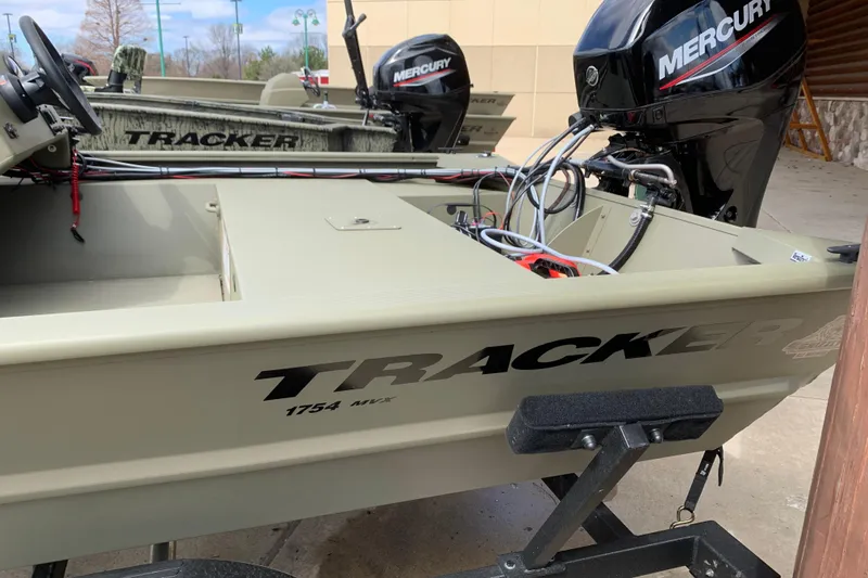 Slide: The Image of 2026 Tracker Grizzly 1754 SC boat with Mercury engine, parked outdoors. - 3