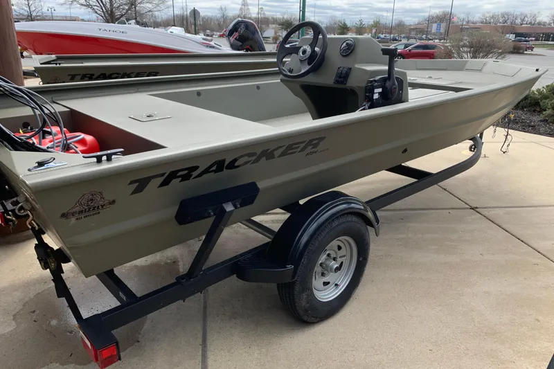 Slide: The Image of 2026 Tracker Grizzly 1754 SC All-Welded boat on trailer, parked outdoors. - 7