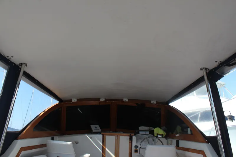 Slide: The Image of 1988 Cape Dory 28 Hardtop interior view with helm and seating area. - 12