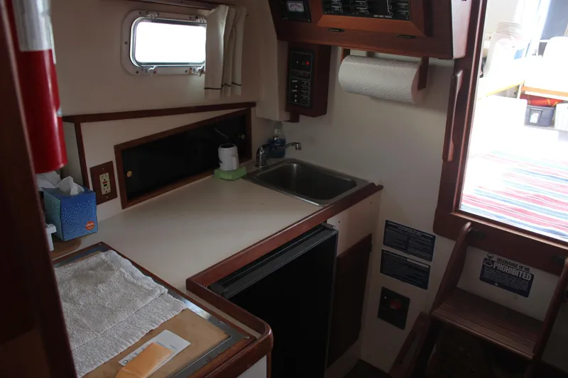 Slide: The Image of Interior of 1988 Cape Dory 28 Hardtop boat featuring compact kitchen area. - 18