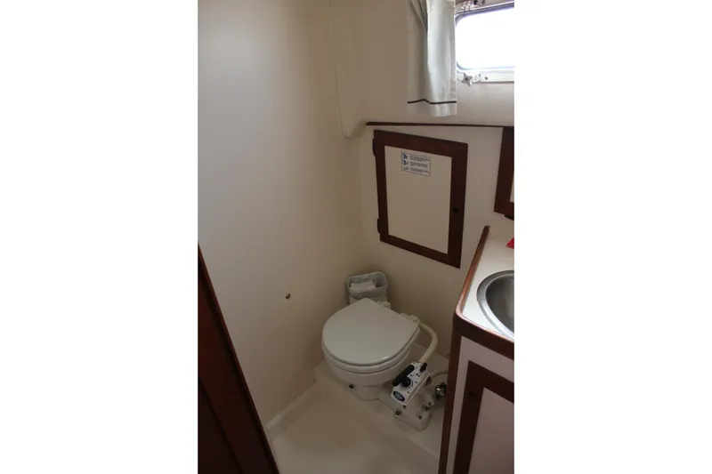 Slide: The Image of 1988 Cape Dory 28 Hardtop boat bathroom with toilet, sink, and window. - 22