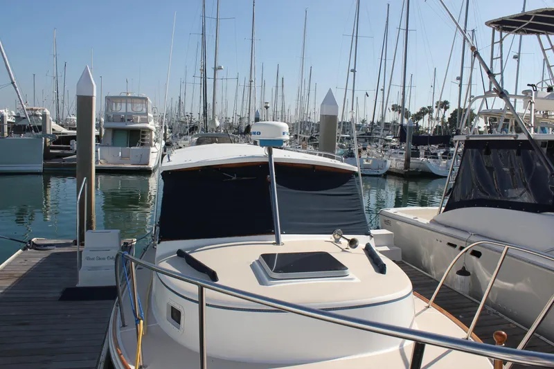 Slide: The Image of 1988 Cape Dory 28 Hardtop docked in a marina with sailboats in the background. - 6
