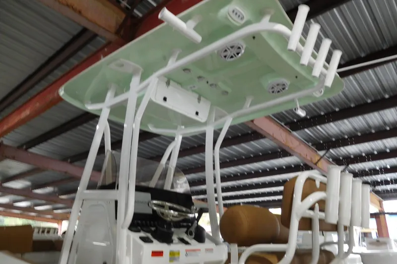 Slide: The Image of 2026 Sea Hunt Ultra 219 boat interior with rod holders and speakers under a metal roof. - 2