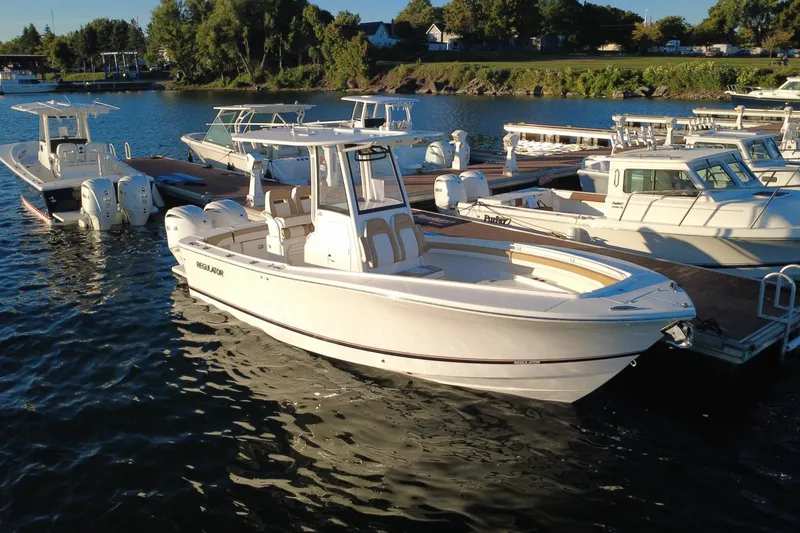 Slide: The Image of 2025 Regulator 25 boat docked in a marina, surrounded by other vessels. - 11