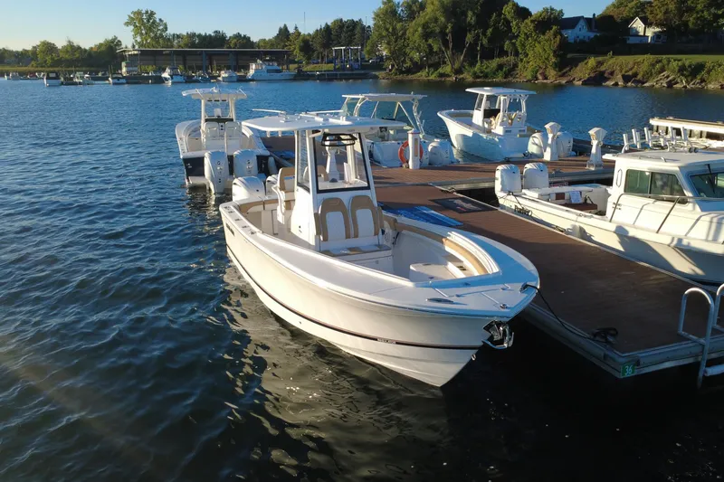 Slide: The Image of 2025 Regulator 25 boat docked at marina, surrounded by other vessels. - 12