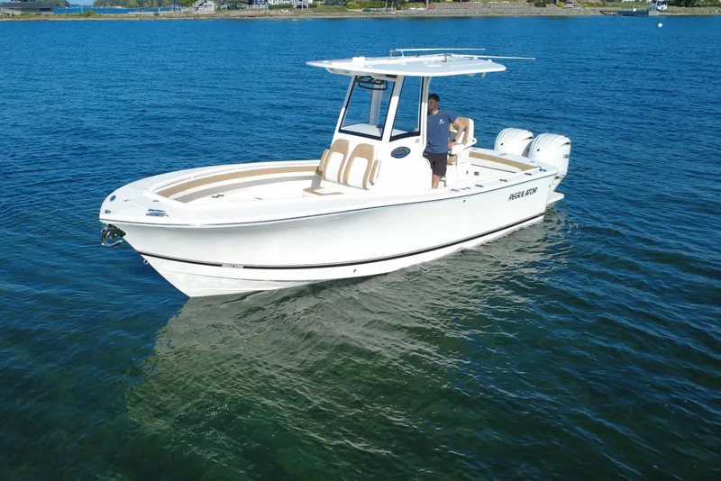 Slide: The Image of 2025 Regulator 25 boat on clear blue water, featuring dual engines and sleek design. - 15