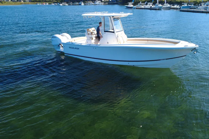 Slide: The Image of 2025 Regulator 25 boat on clear water, with a person at the helm. - 17