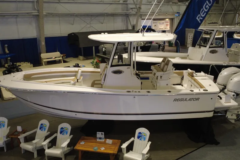 Slide: The Image of 2025 Regulator 25 boat displayed indoors, showcasing sleek design and modern features. - 18