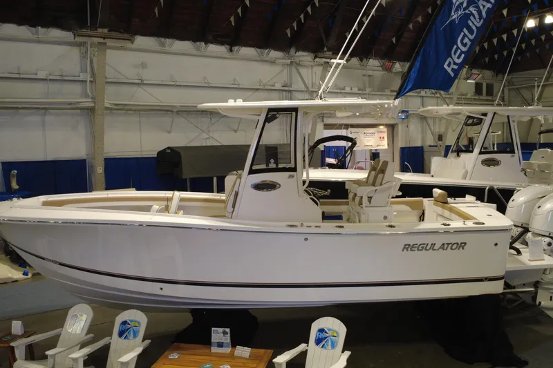 Slide: The Image of 2025 Regulator 25 boat displayed indoors at a boat show. - 20