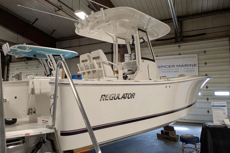 Slide: The Image of 2025 Regulator 25 boat displayed indoors at Spicer Marine showroom. - 23