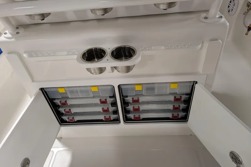 Slide: The Image of 2025 Regulator 25 boat storage compartments with tackle boxes and cup holders. - 30