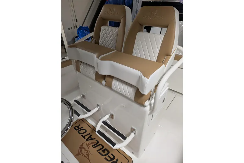Slide: The Image of 2025 Regulator 25 boat seats with tan and white quilted design, featuring Regulator branding. - 34