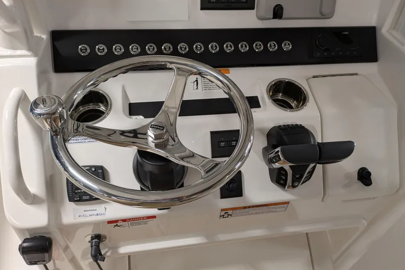 Slide: The Image of Steering console of 2025 Regulator 25 boat with modern controls and chrome wheel. - 35