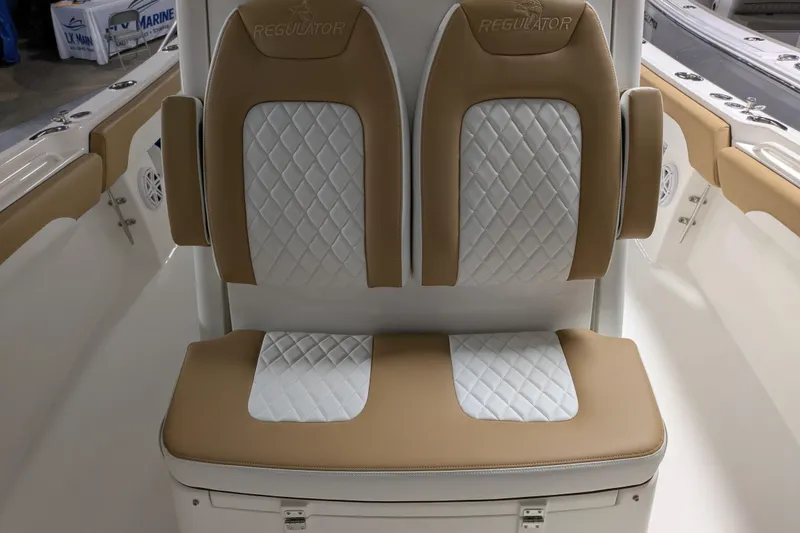Slide: The Image of 2025 Regulator 25 boat seats with tan and white quilted upholstery. - 38