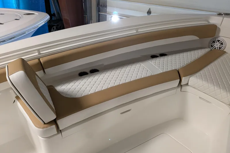 Slide: The Image of Luxurious seating on 2025 Regulator 25 boat, featuring tan and white quilted upholstery. - 40