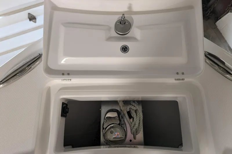 Slide: The Image of Open storage compartment on a 2025 Regulator 25 boat, featuring ropes and equipment. - 43