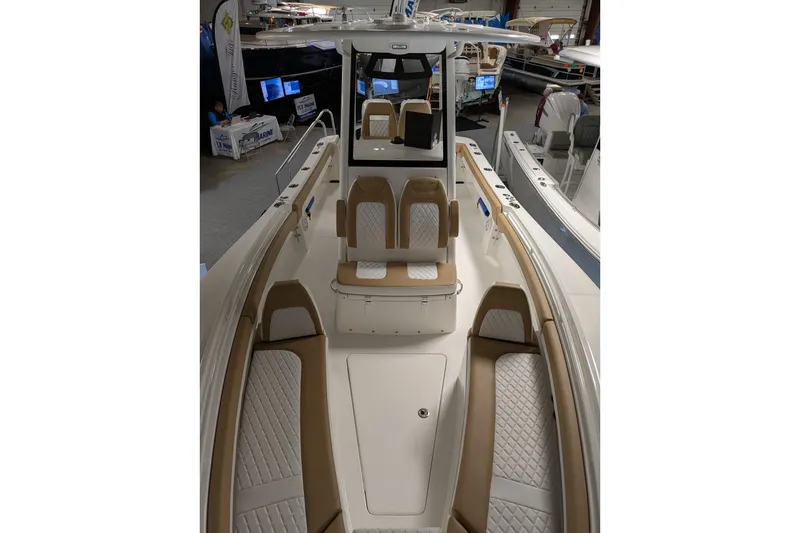 Slide: The Image of 2025 Regulator 25 boat interior with tan and white seating, showcased at a marine exhibition. - 45