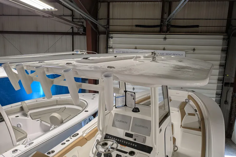 Slide: The Image of 2025 Regulator 25 boat interior with Garmin electronics and rod holders in a showroom. - 46