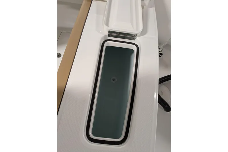 Slide: The Image of 2025 Regulator 25 boat storage compartment with open lid, showcasing sleek design. - 47