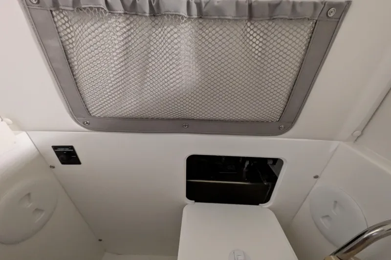 Slide: The Image of Interior of 2025 Regulator 25 boat with storage compartment and mesh pocket. - 58