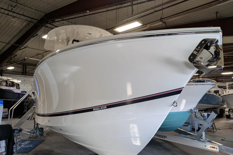 Slide: The Image of 2025 Regulator 25 boat displayed indoors, showcasing sleek design and modern features. - 59