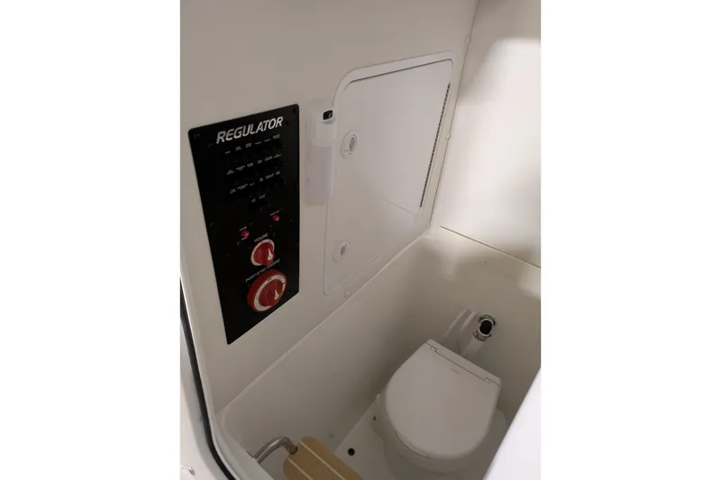 Slide: The Image of 2025 Regulator 25 boat interior with control panel and compact toilet. - 61