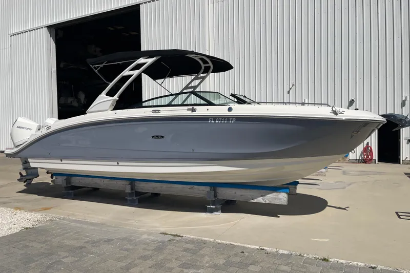 The Image of 2023 Sea Ray SDX 290 Outboard boat on display outside a large warehouse. - 0