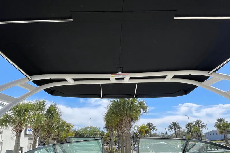 Slide: The Image of 2023 Sea Ray SDX 290 Outboard boat canopy with palm trees in the background. - 19
