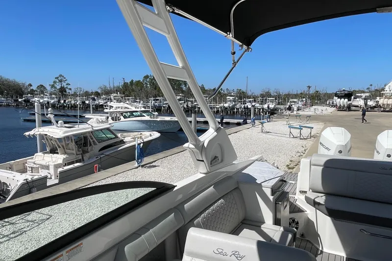 Slide: The Image of 2023 Sea Ray SDX 290 Outboard at marina, showcasing luxury seating and scenic waterfront. - 27