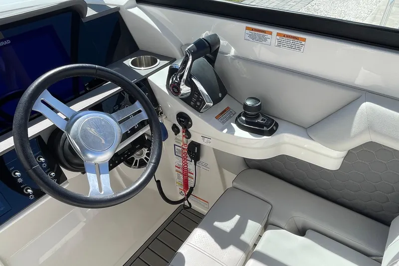 Slide: The Image of 2023 Sea Ray SDX 290 Outboard helm with steering wheel and controls. - 7