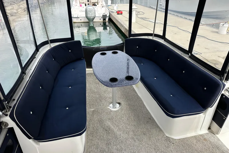Slide: The Image of Interior of 2012 ElectraCraft CAT 16 boat with blue cushioned seating and table. - 11